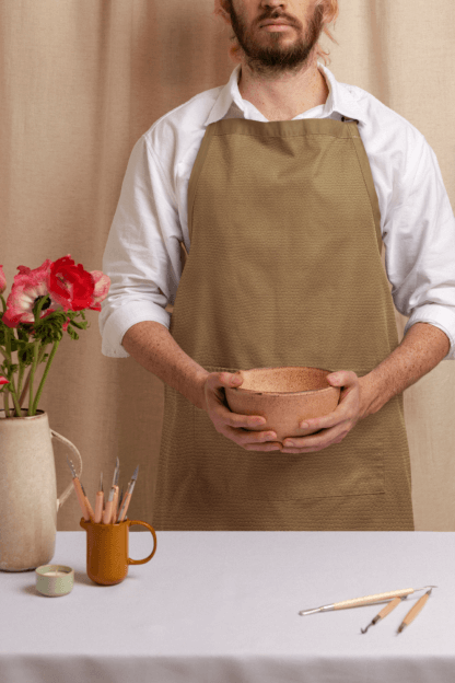 A Cook wearing our Luxe Tan Whispers Apron @ lookwhoscookinnow.com